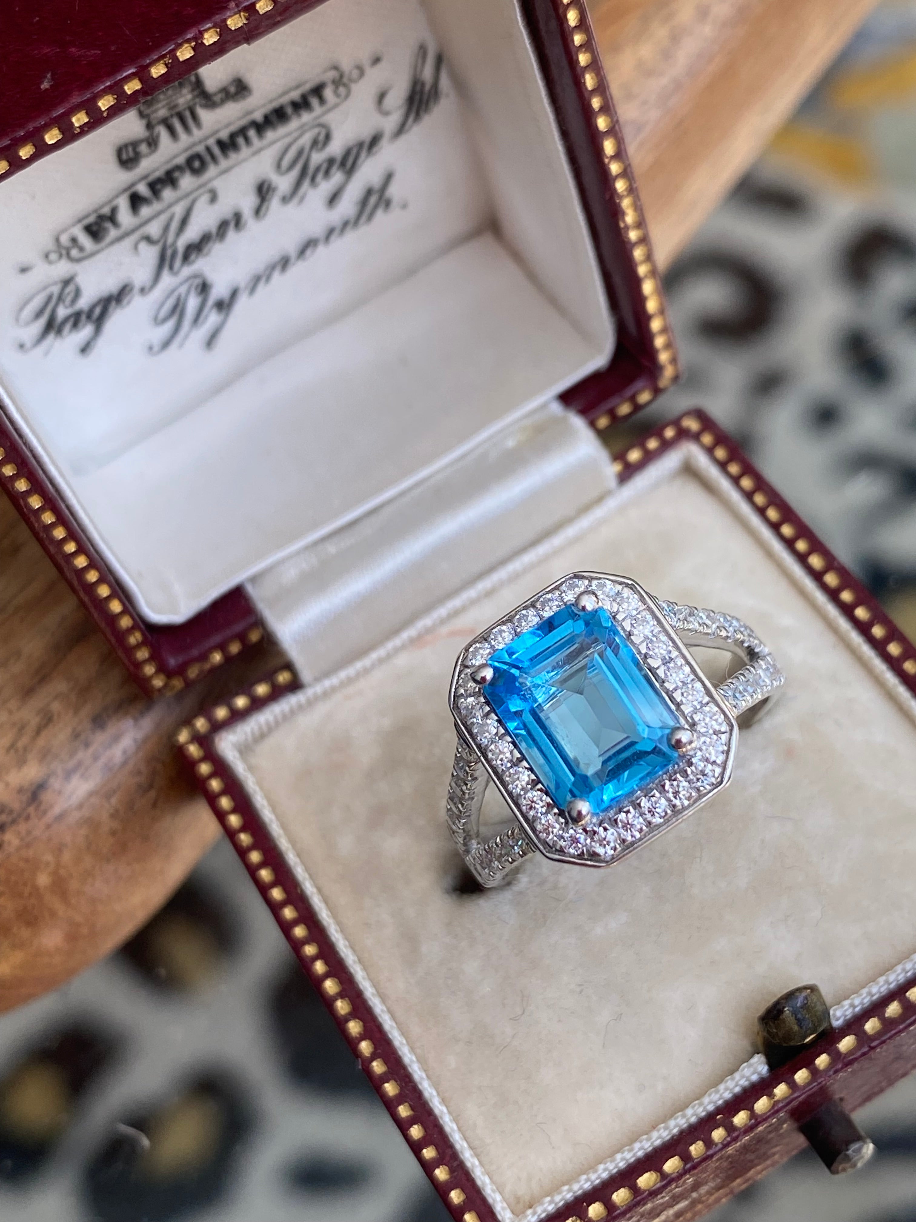 3.10 CTW Emerald Cut Moissanite and Blue Topaz Halo Ring in Sterling Silver