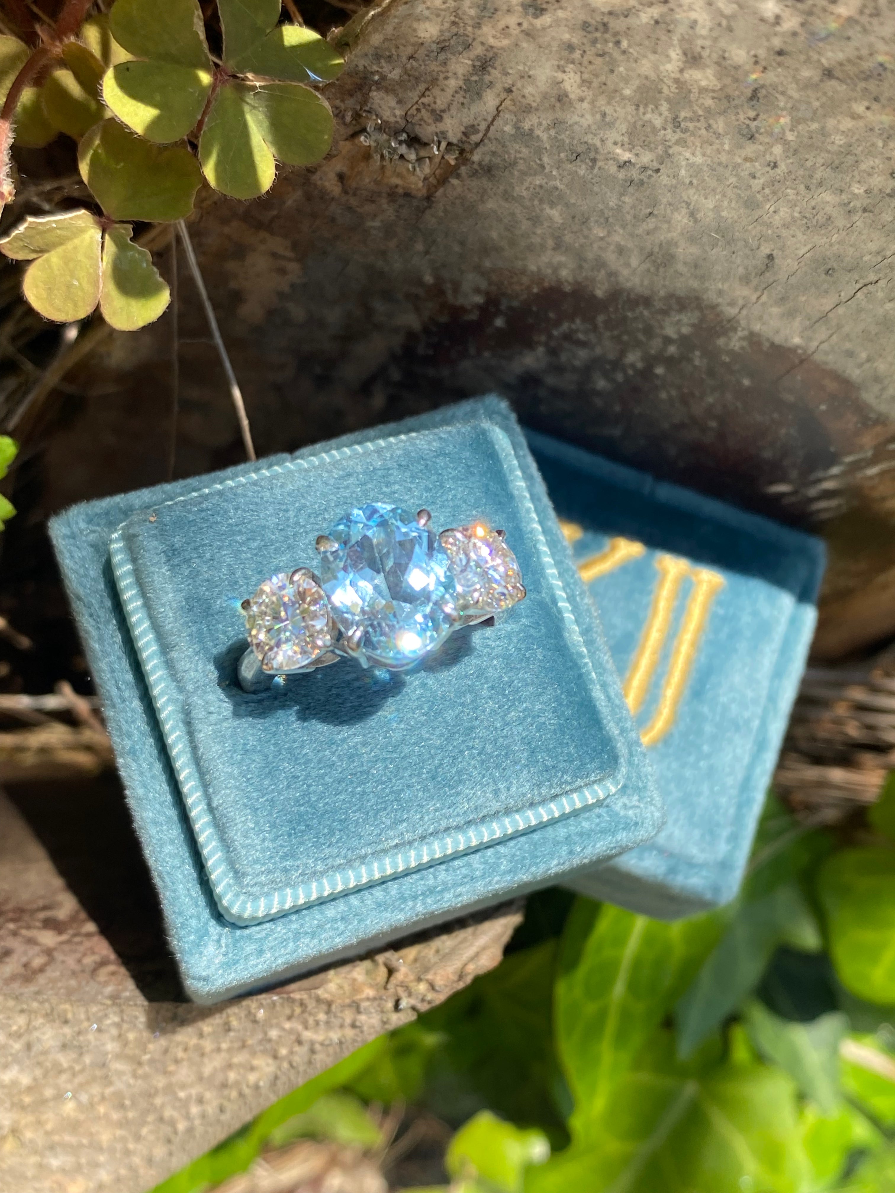 3.99 Carat Oval Cut Blue Topaz and 1.85 Carat Moissanite Three Stone Ring in Sterling Silver