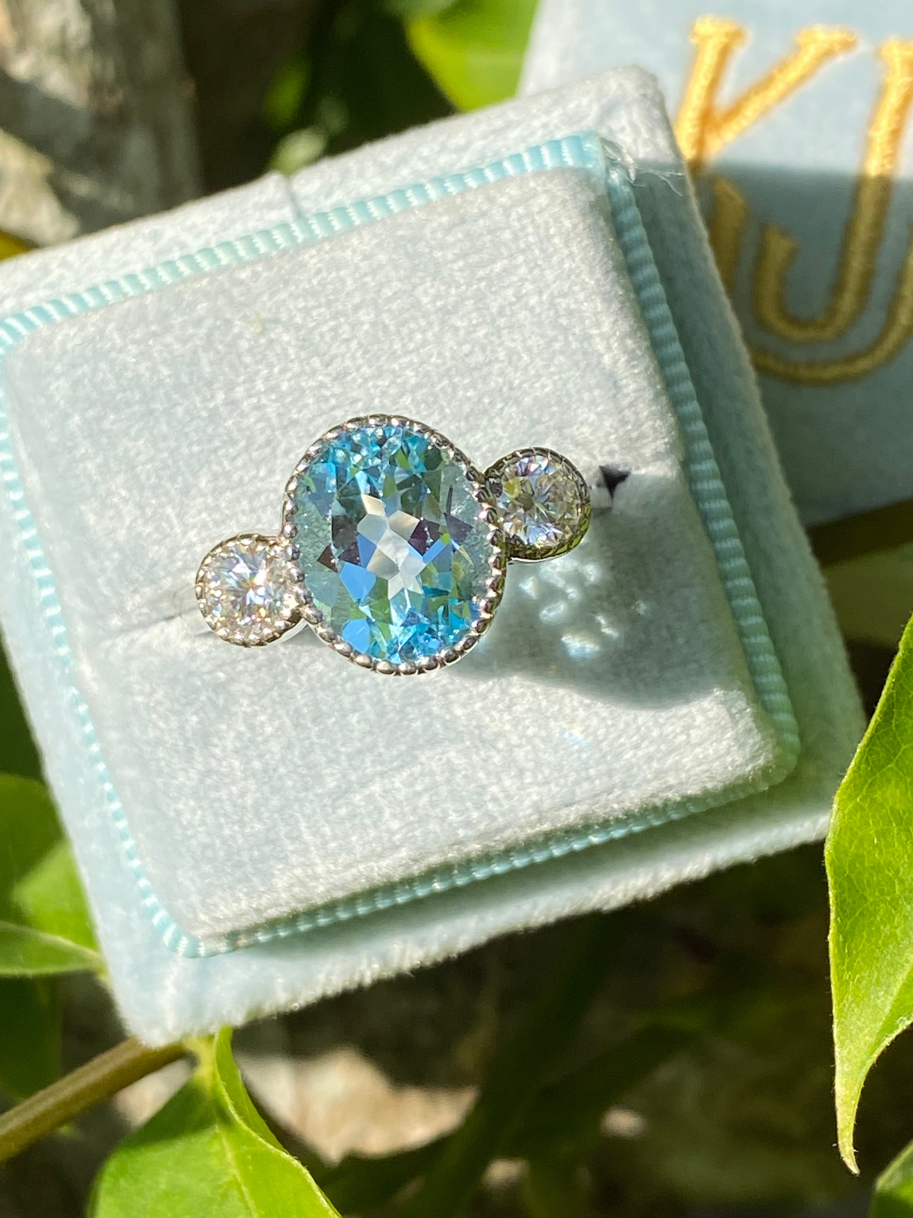 3.34 Carat Oval Cut Blue Topaz and Moissanite Three Stone Ring in Sterling Silver