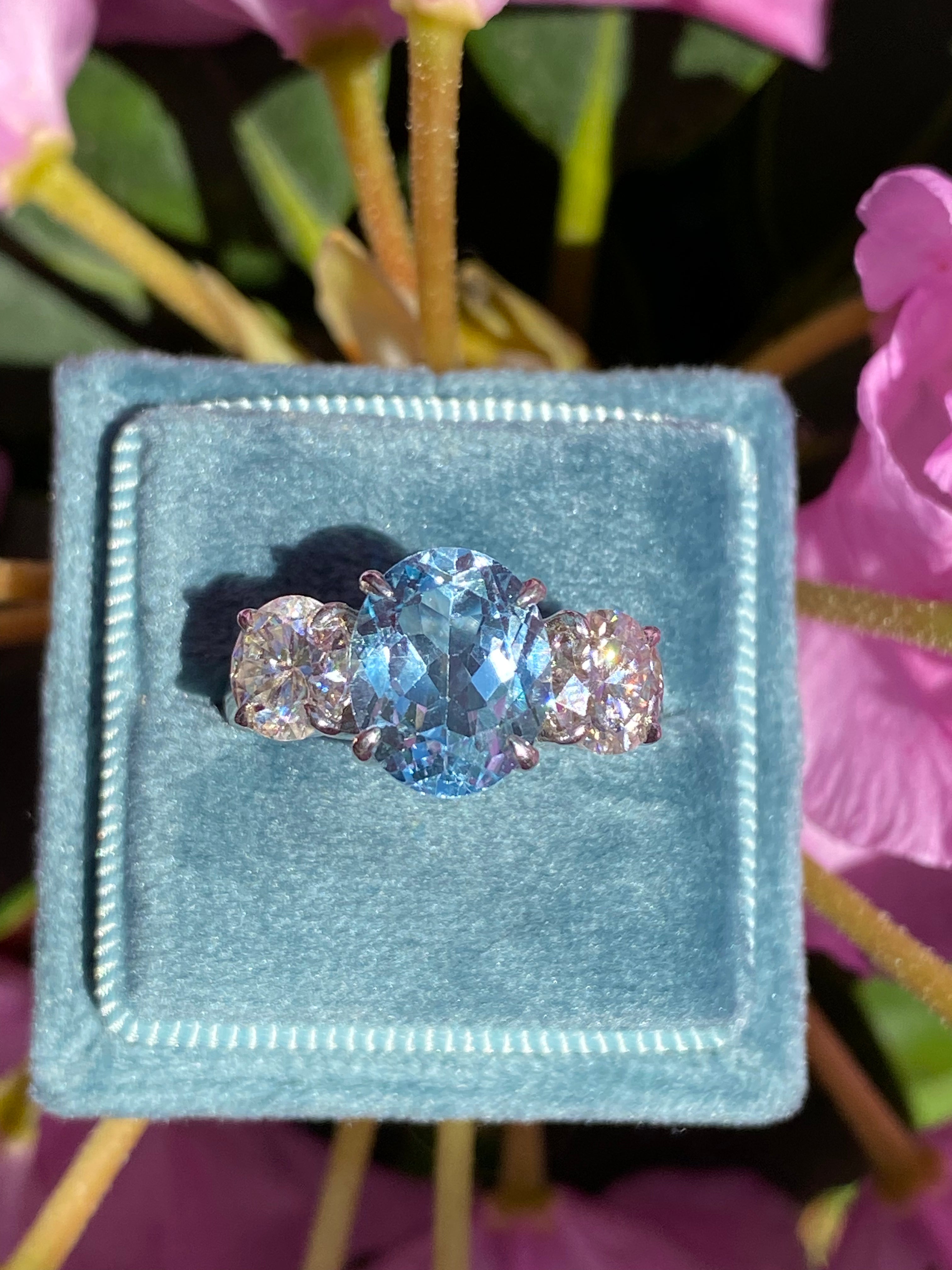 3.99 Carat Oval Cut Blue Topaz and 1.85 Carat Moissanite Three Stone Ring in Sterling Silver