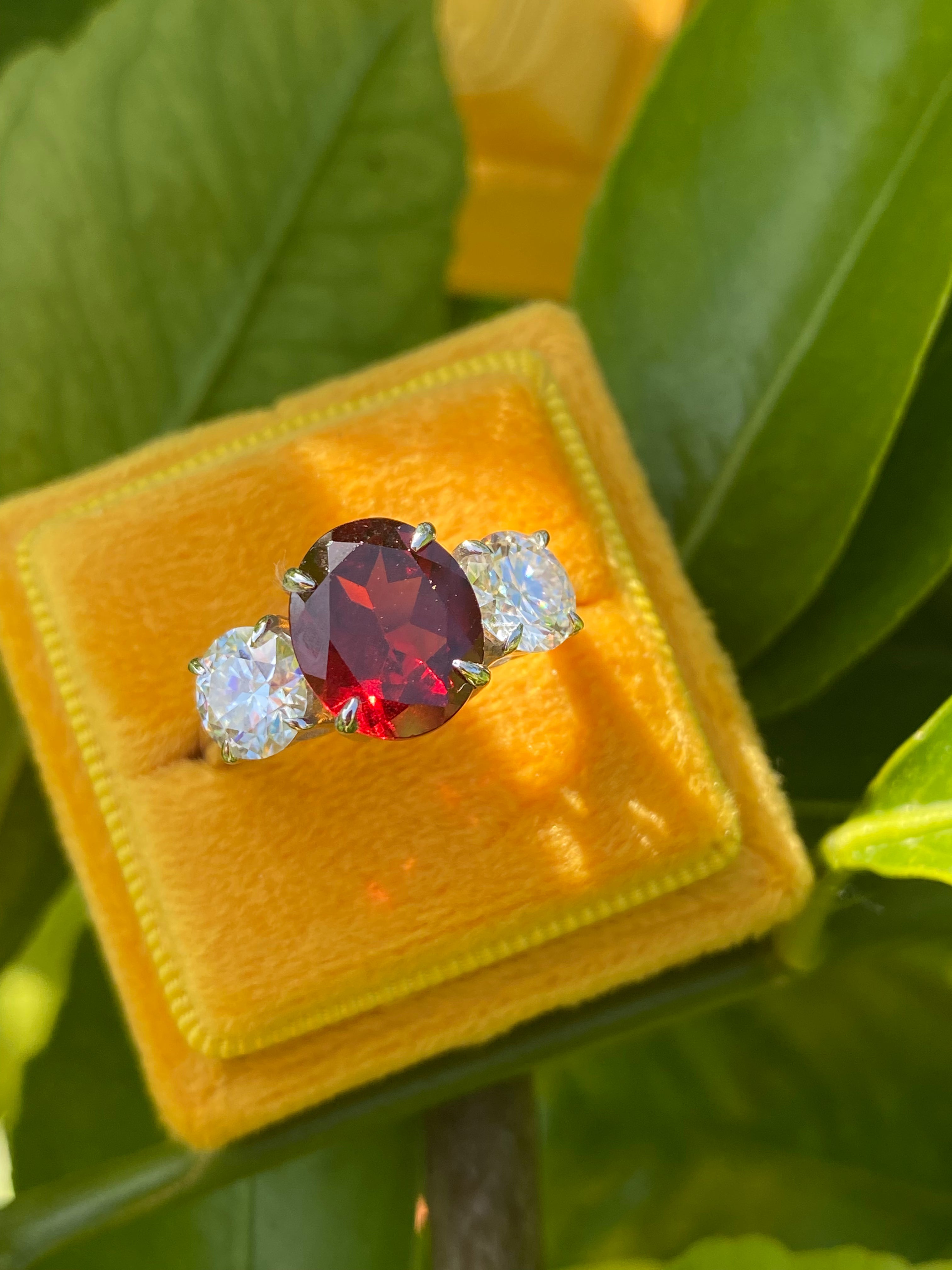 4.10 Carat Oval Cut Garnet and 1.85 Carat Moissanite Three Stone Ring in Sterling Silver