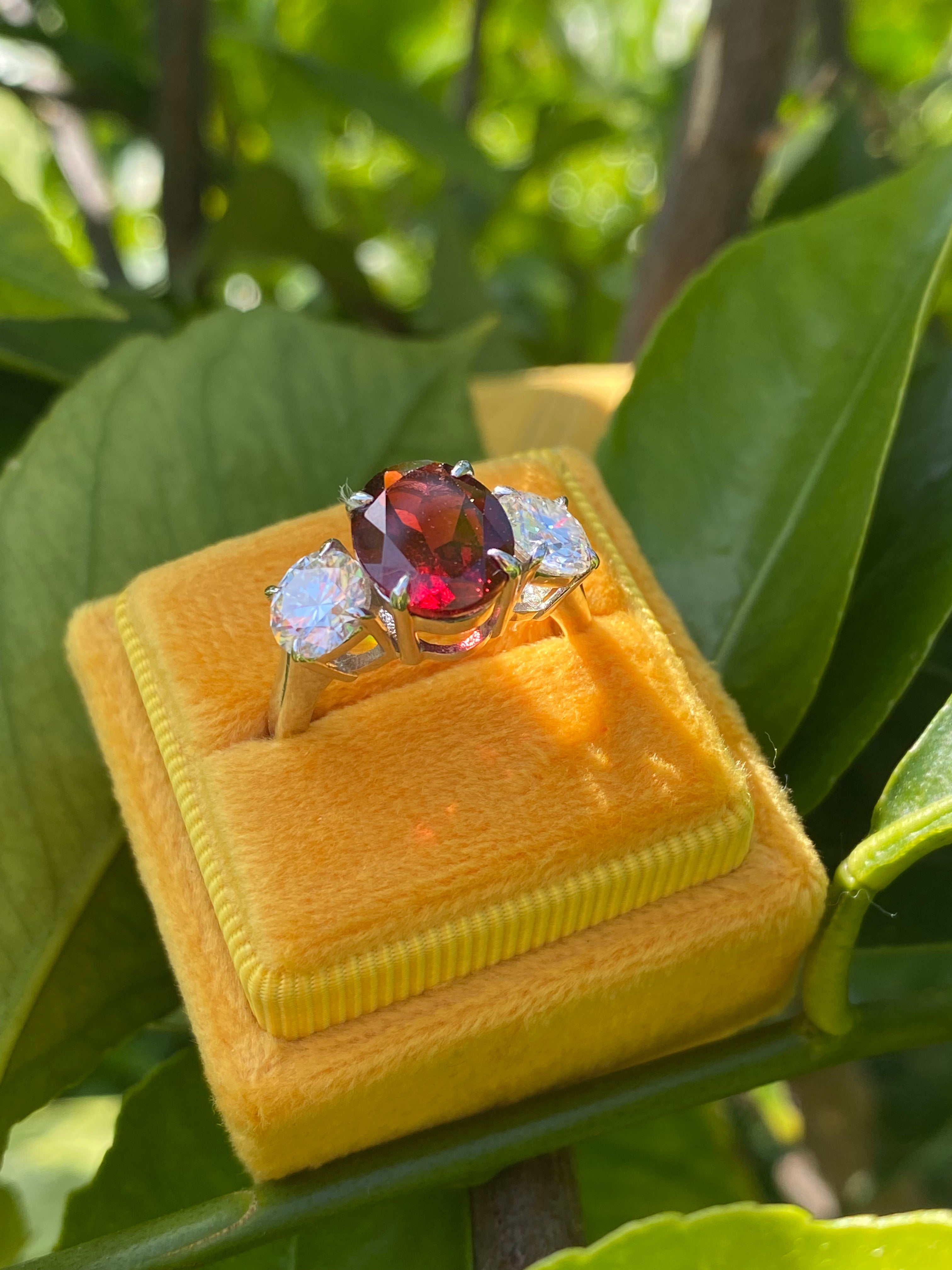 4.10 Carat Oval Cut Garnet and 1.85 Carat Moissanite Three Stone Ring in Sterling Silver