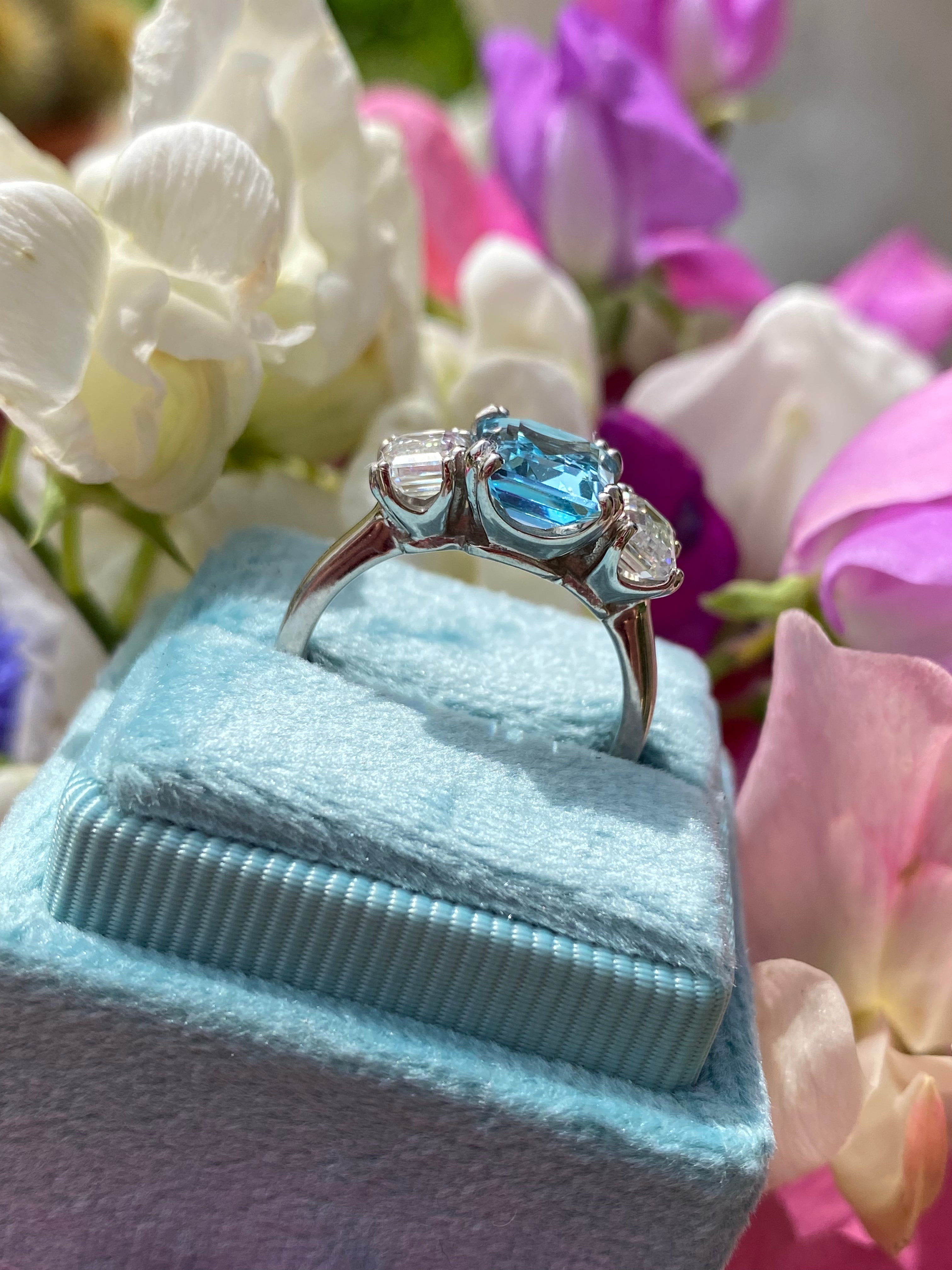 3.50 CTW Emerald Cut Blue Topaz and Moissanite Three Stone Ring in Sterling Silver