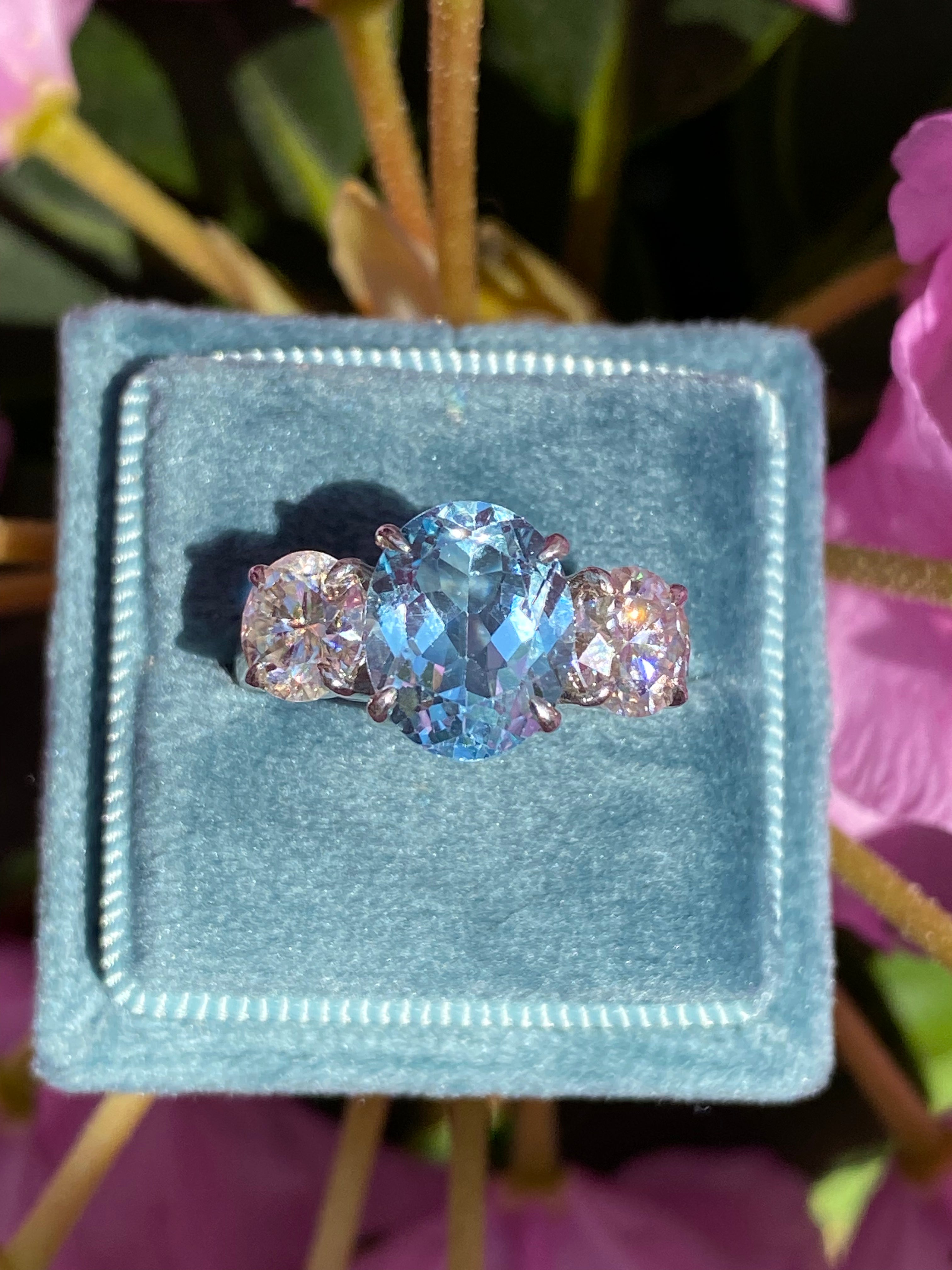 3.99 Carat Oval Cut Blue Topaz and 1.85 Carat Moissanite Three Stone Ring in Sterling Silver