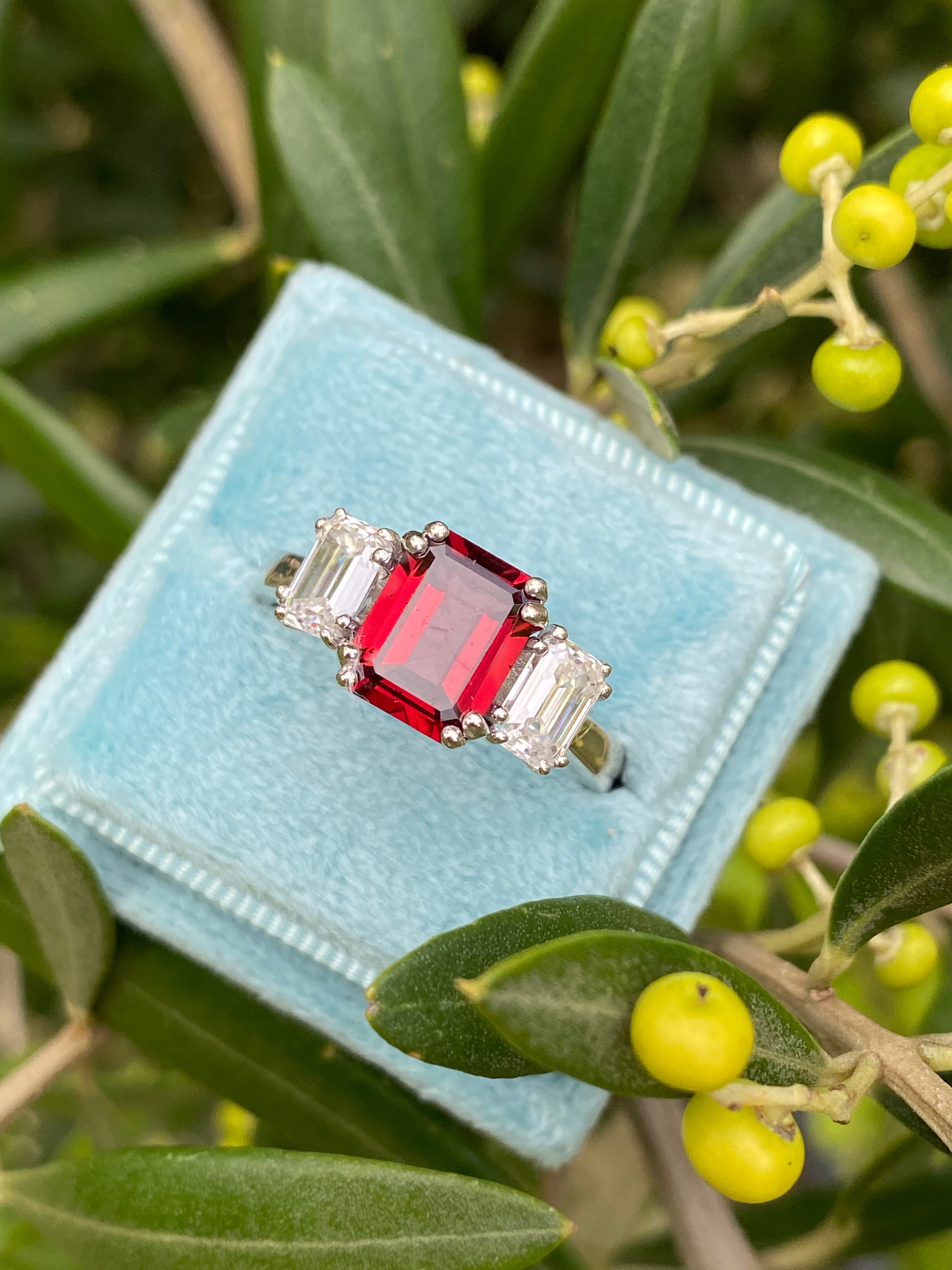 3.50 CTW Emerald Cut Garnet and Moissanite Three Stone Ring in Sterling Silver