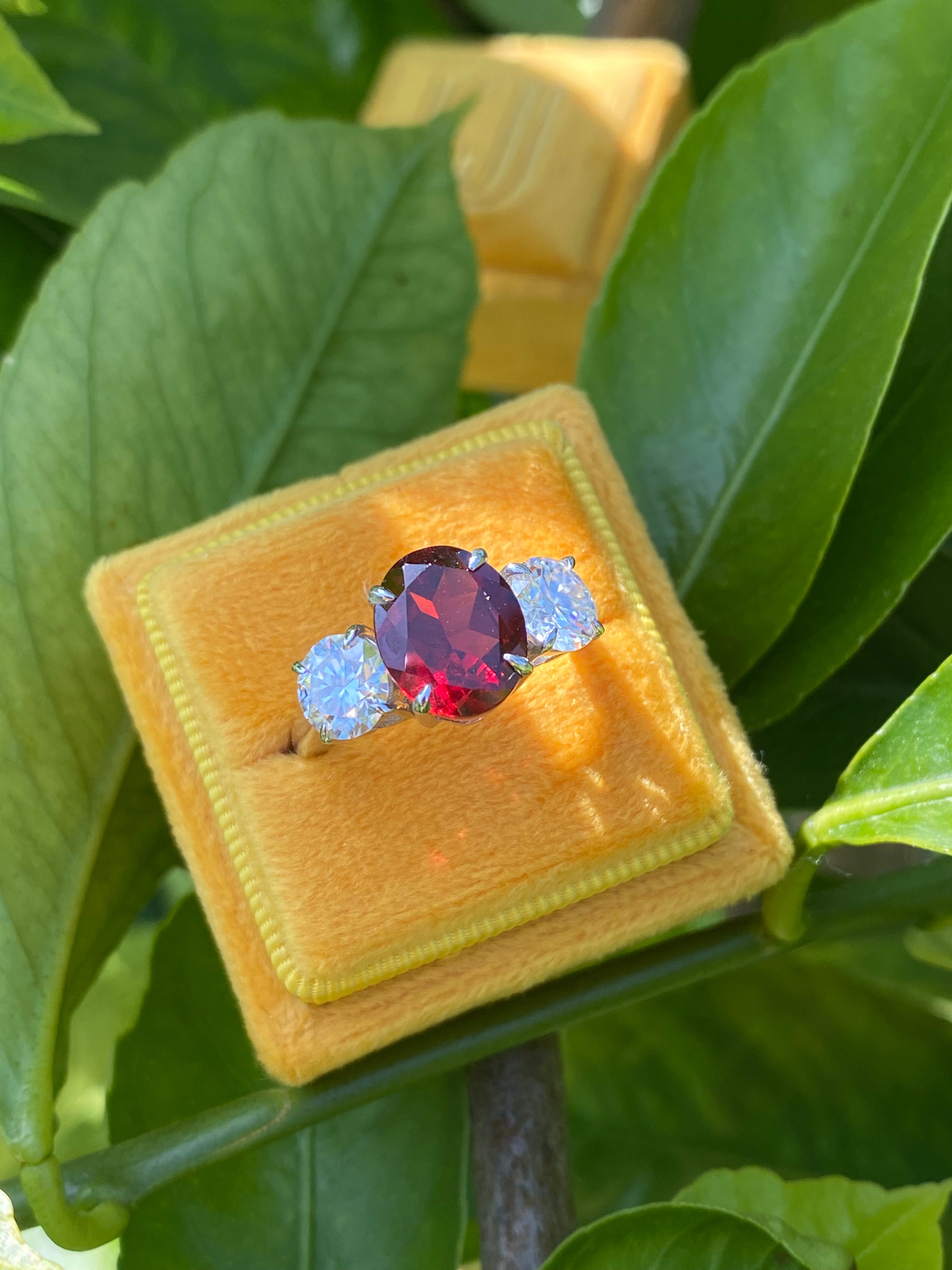 4.10 Carat Oval Cut Garnet and 1.85 Carat Moissanite Three Stone Ring in Sterling Silver