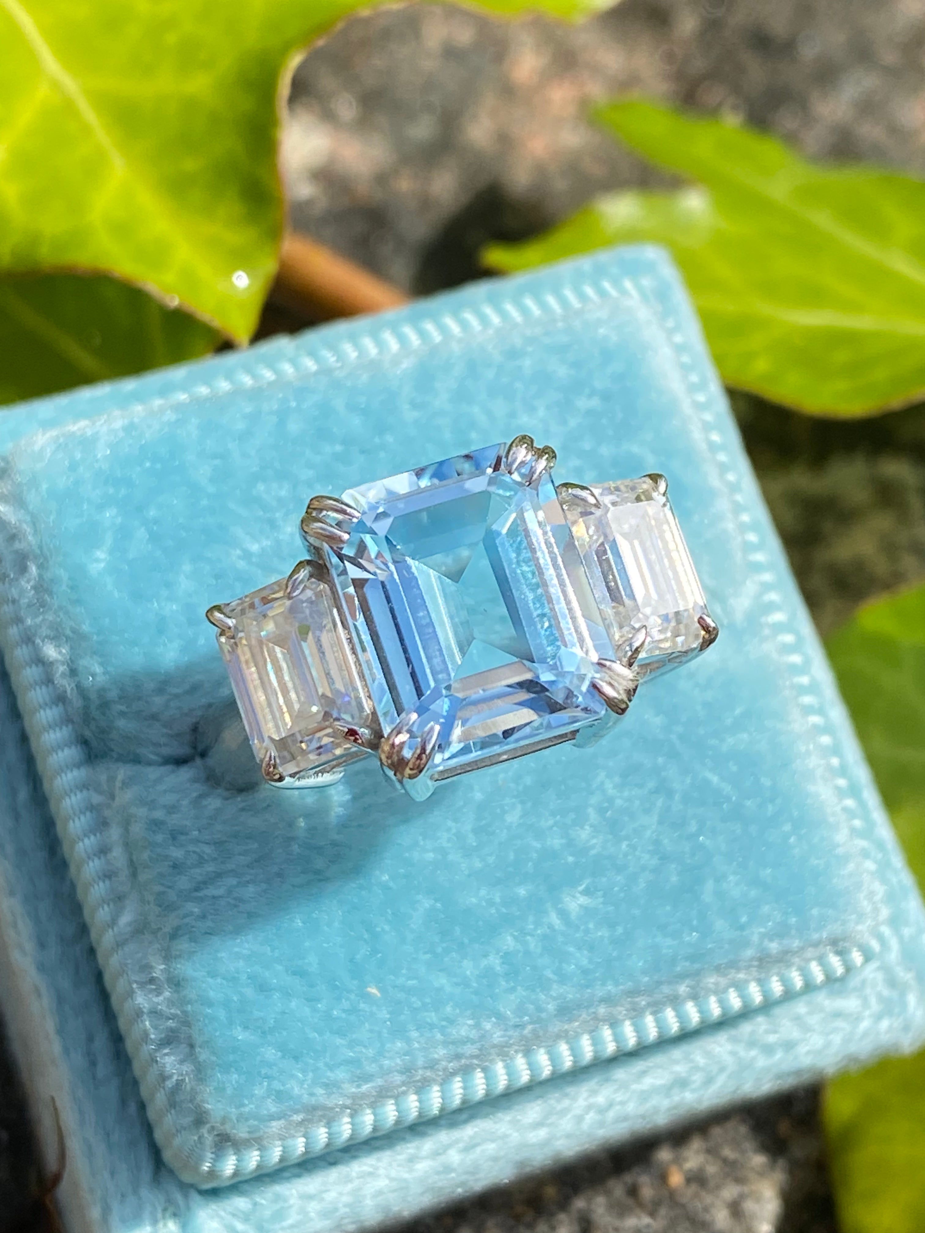 5.71 Carat Emerald Cut Blue Topaz and 2.00 Carat Moissanite Three Stone Ring in Sterling Silver