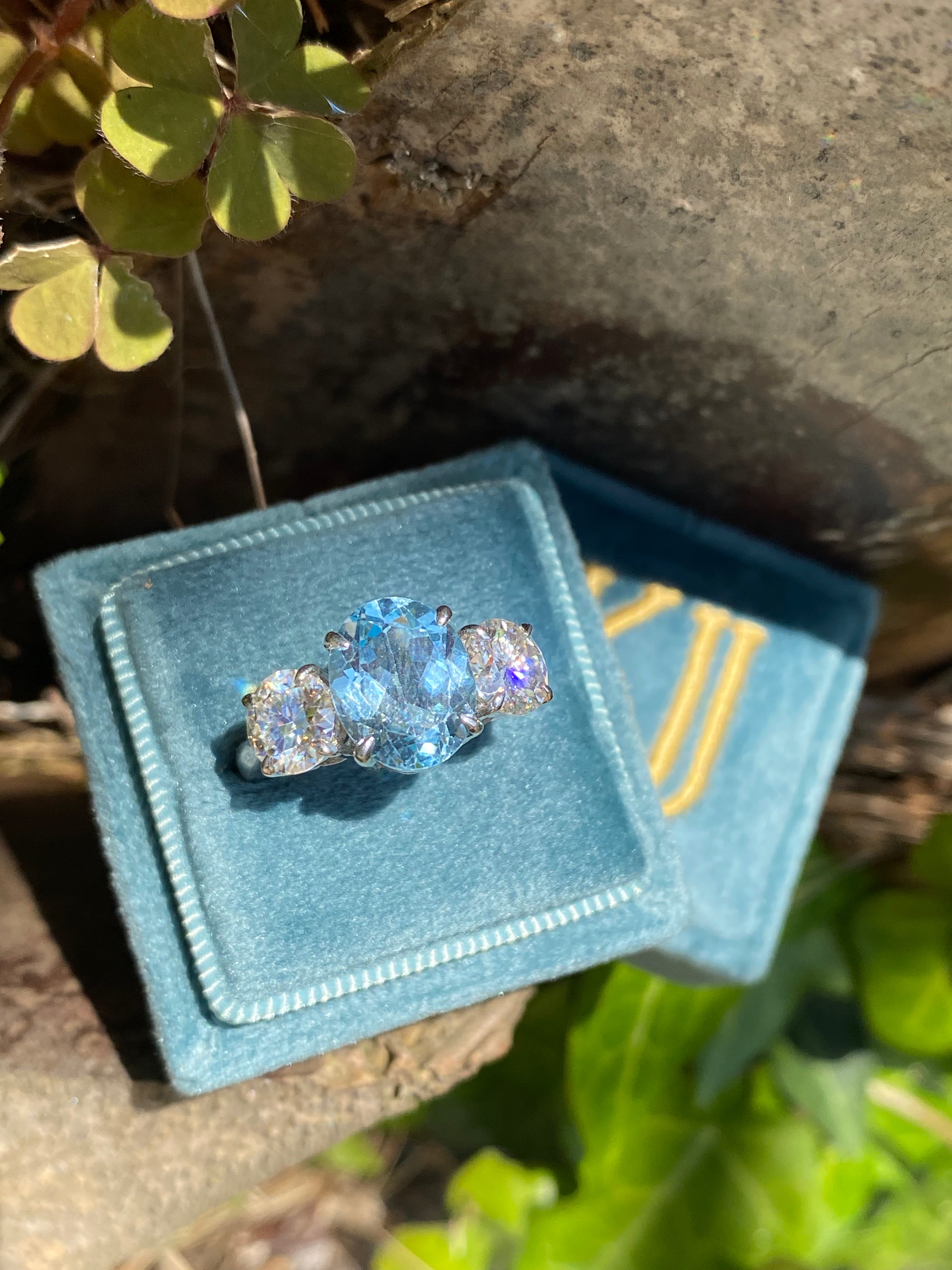 3.99 Carat Oval Cut Blue Topaz and 1.85 Carat Moissanite Three Stone Ring in Sterling Silver