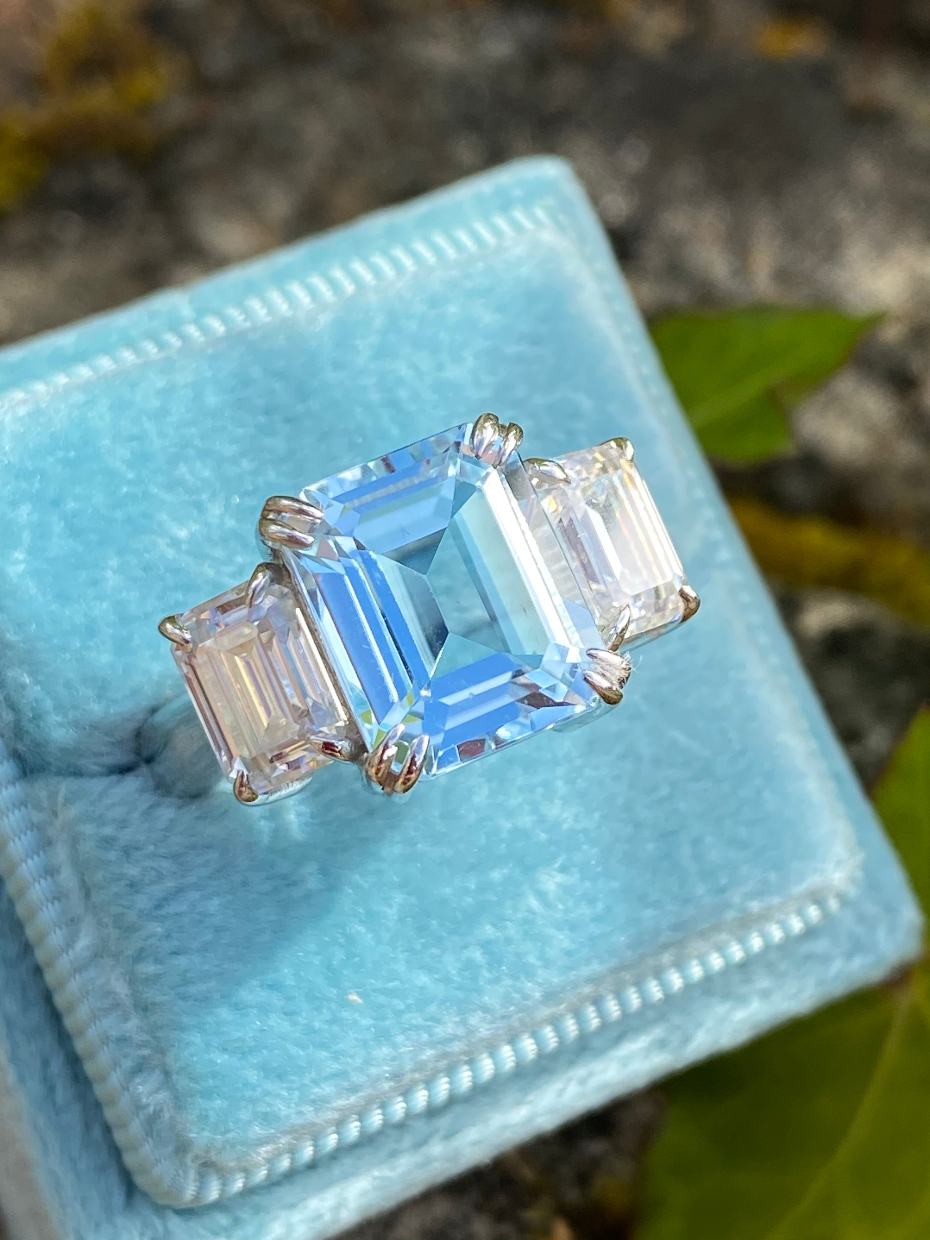 5.71 Carat Emerald Cut Blue Topaz and 2.00 Carat Moissanite Three Stone Ring in Sterling Silver