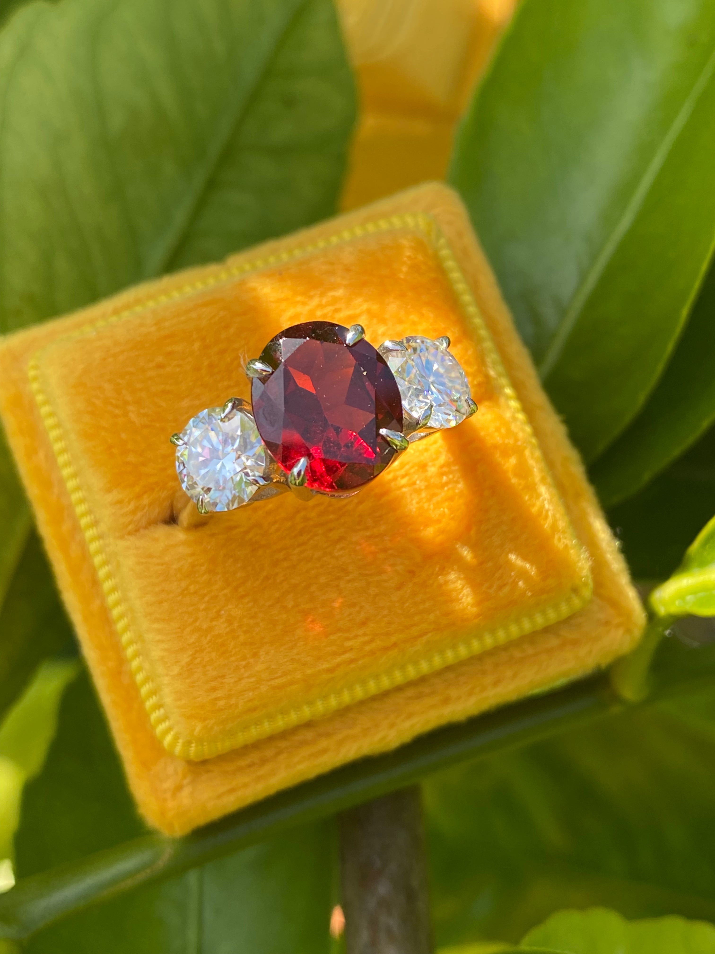4.10 Carat Oval Cut Garnet and 1.85 Carat Moissanite Three Stone Ring in Sterling Silver