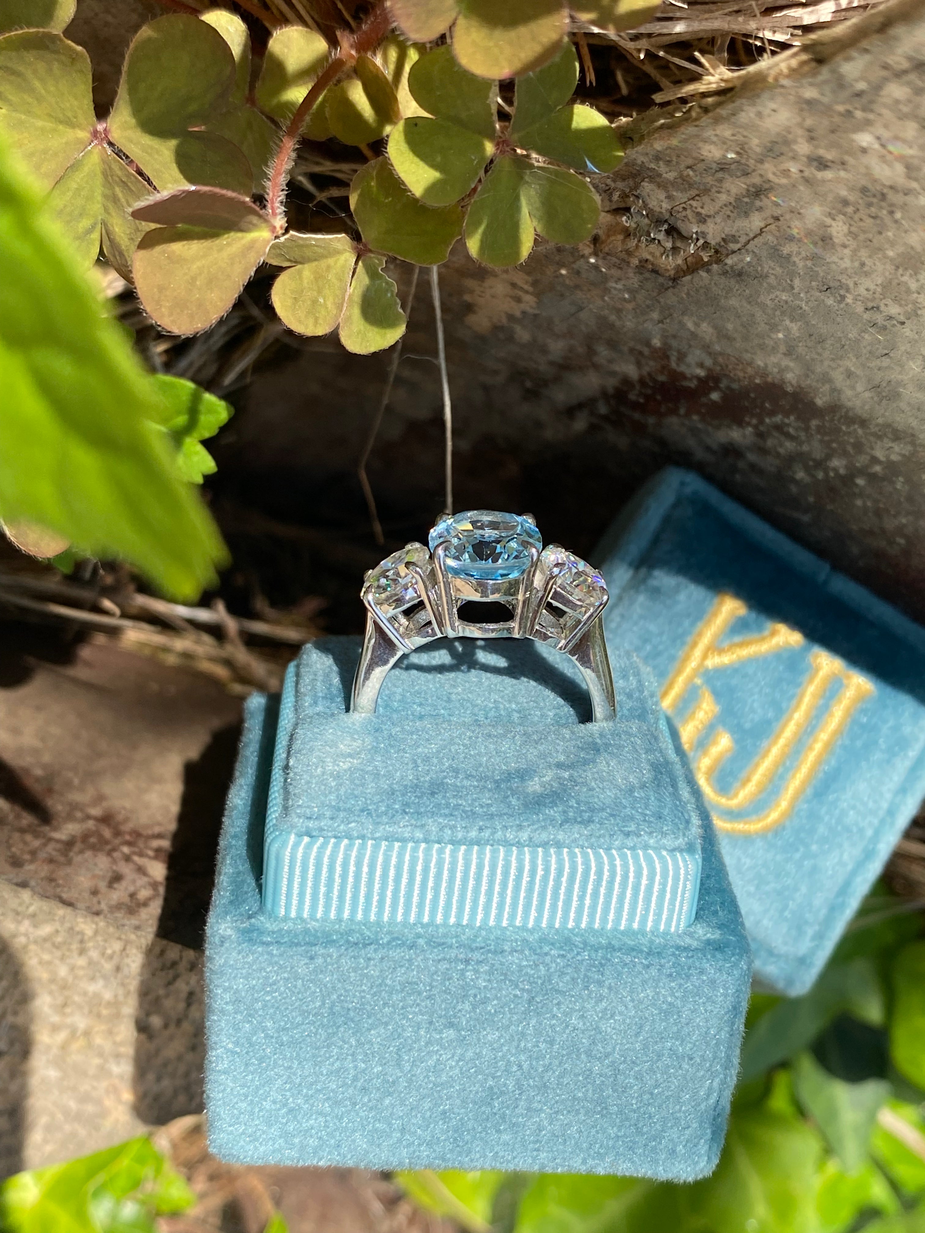 3.99 Carat Oval Cut Blue Topaz and 1.85 Carat Moissanite Three Stone Ring in Sterling Silver