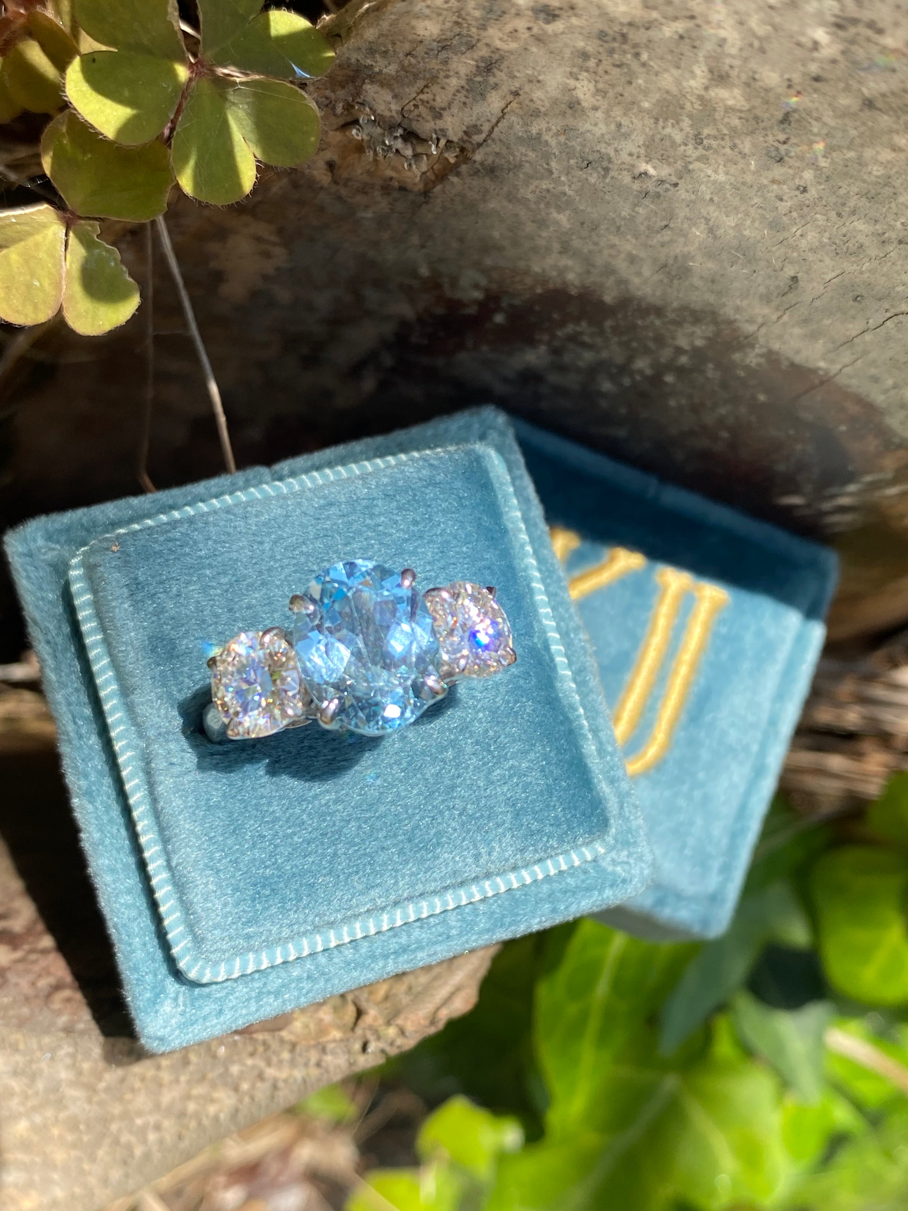 3.99 Carat Oval Cut Blue Topaz and 1.85 Carat Moissanite Three Stone Ring in Sterling Silver
