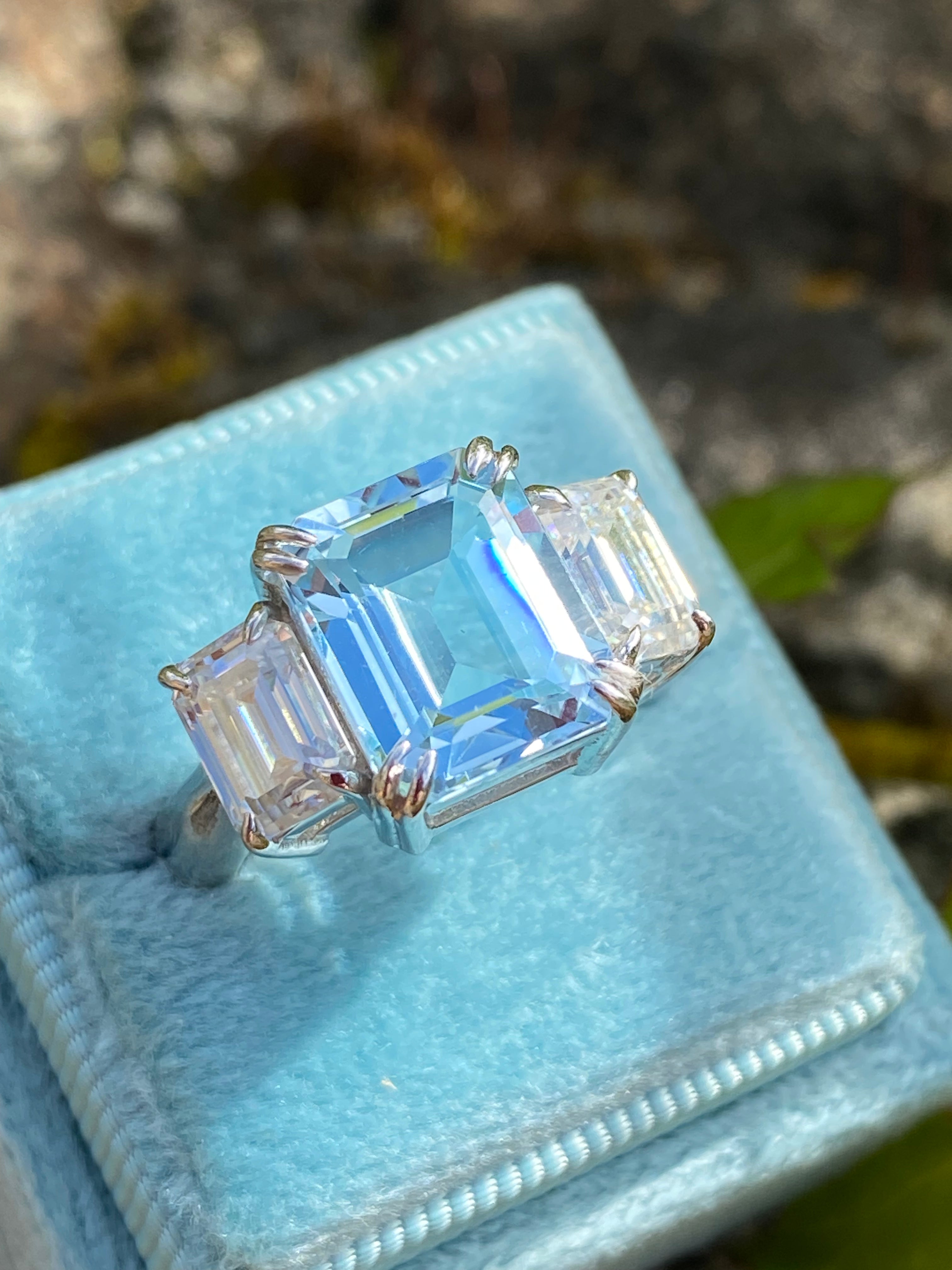 5.71 Carat Emerald Cut Blue Topaz and 2.00 Carat Moissanite Three Stone Ring in Sterling Silver