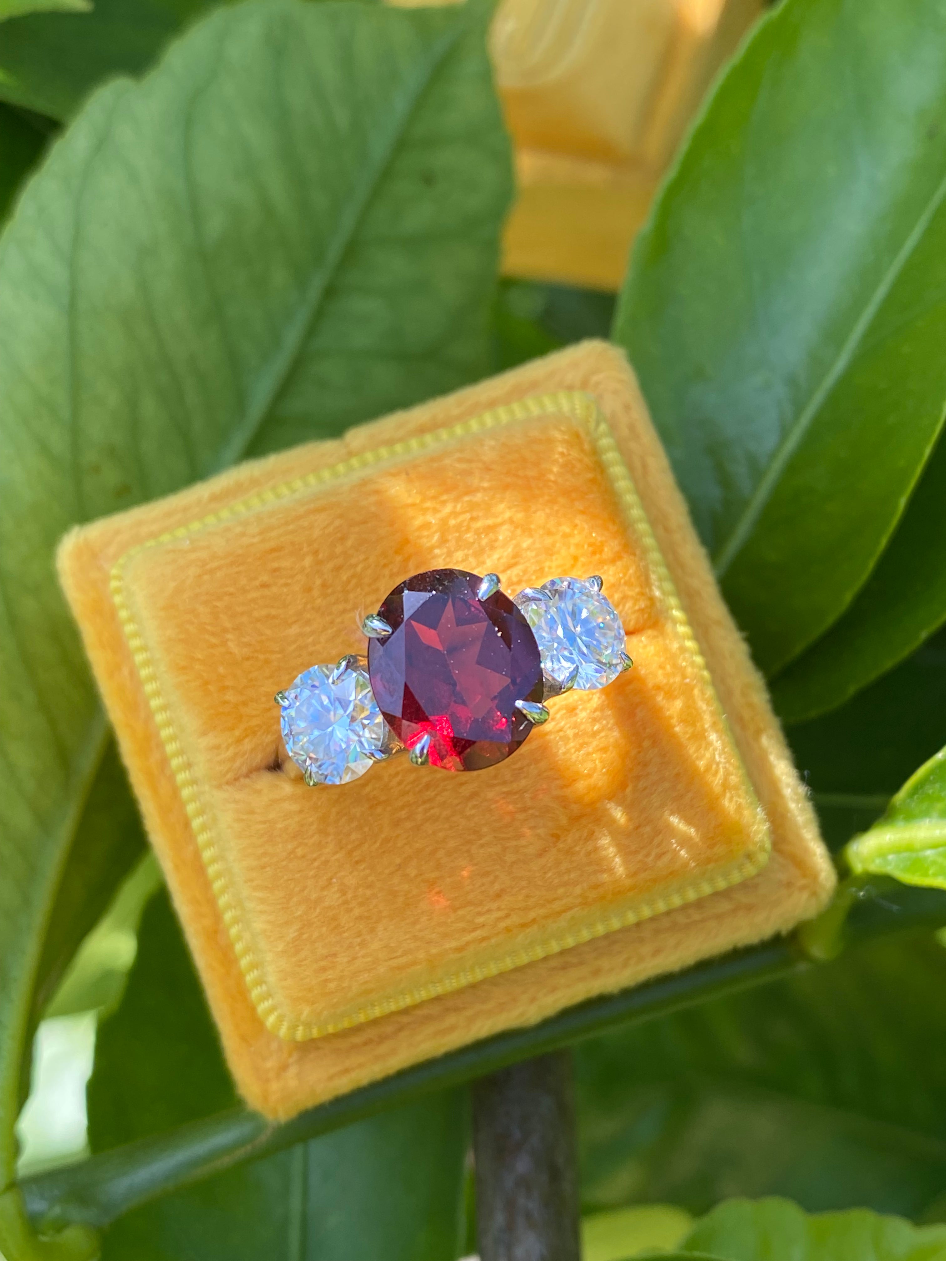 4.10 Carat Oval Cut Garnet and 1.85 Carat Moissanite Three Stone Ring in Sterling Silver