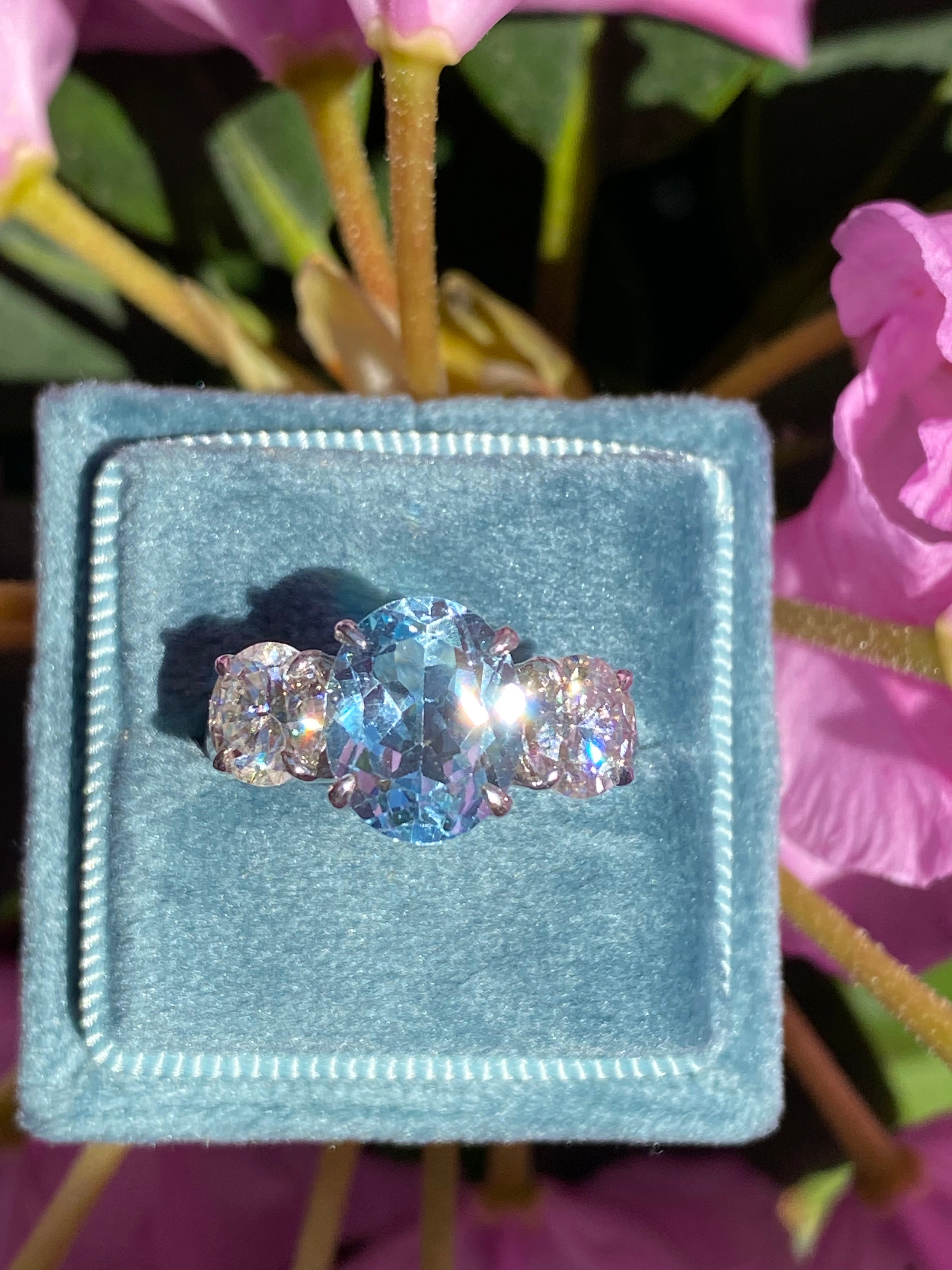 3.99 Carat Oval Cut Blue Topaz and 1.85 Carat Moissanite Three Stone Ring in Sterling Silver