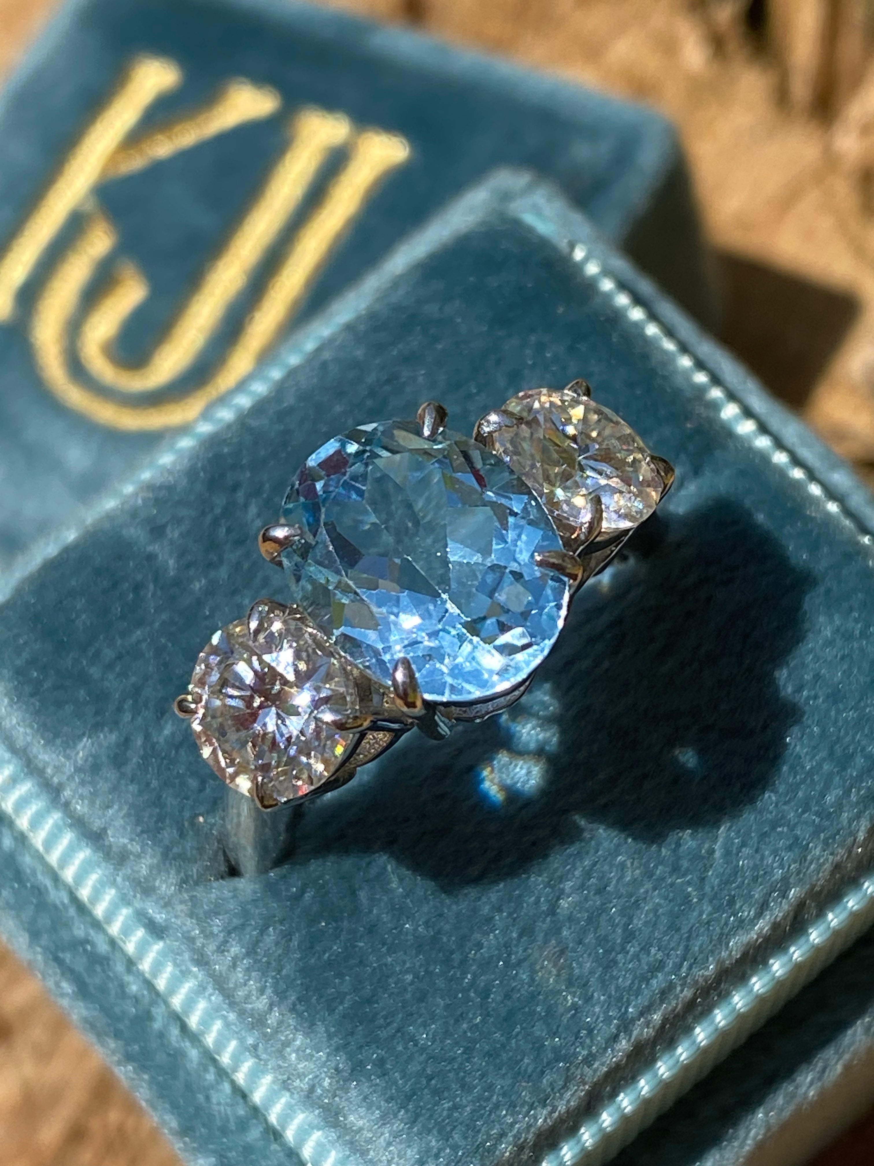 3.99 Carat Oval Cut Blue Topaz and 1.85 Carat Moissanite Three Stone Ring in Sterling Silver