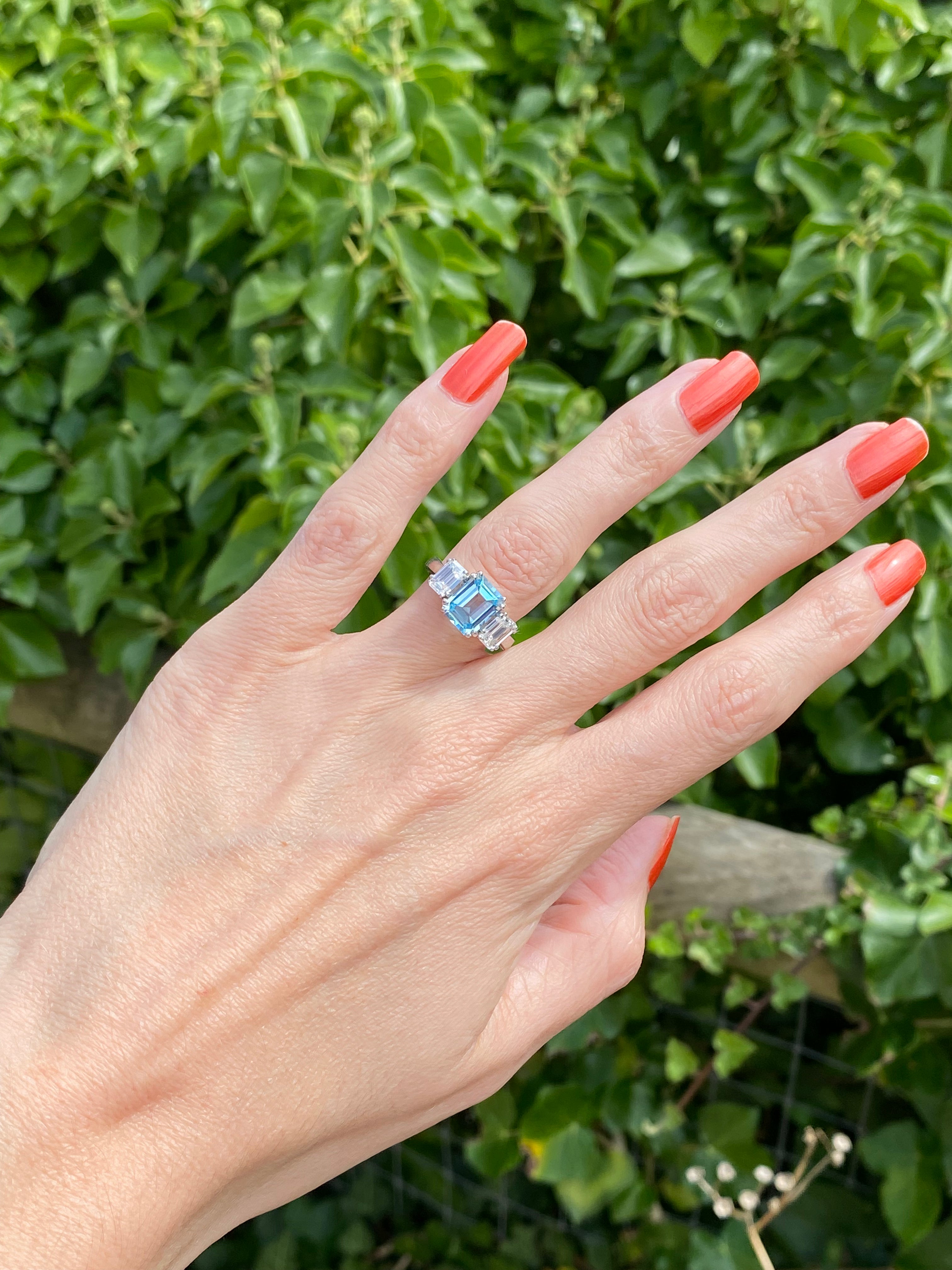 3.50 CTW Emerald Cut Blue Topaz and Moissanite Three Stone Ring in Sterling Silver