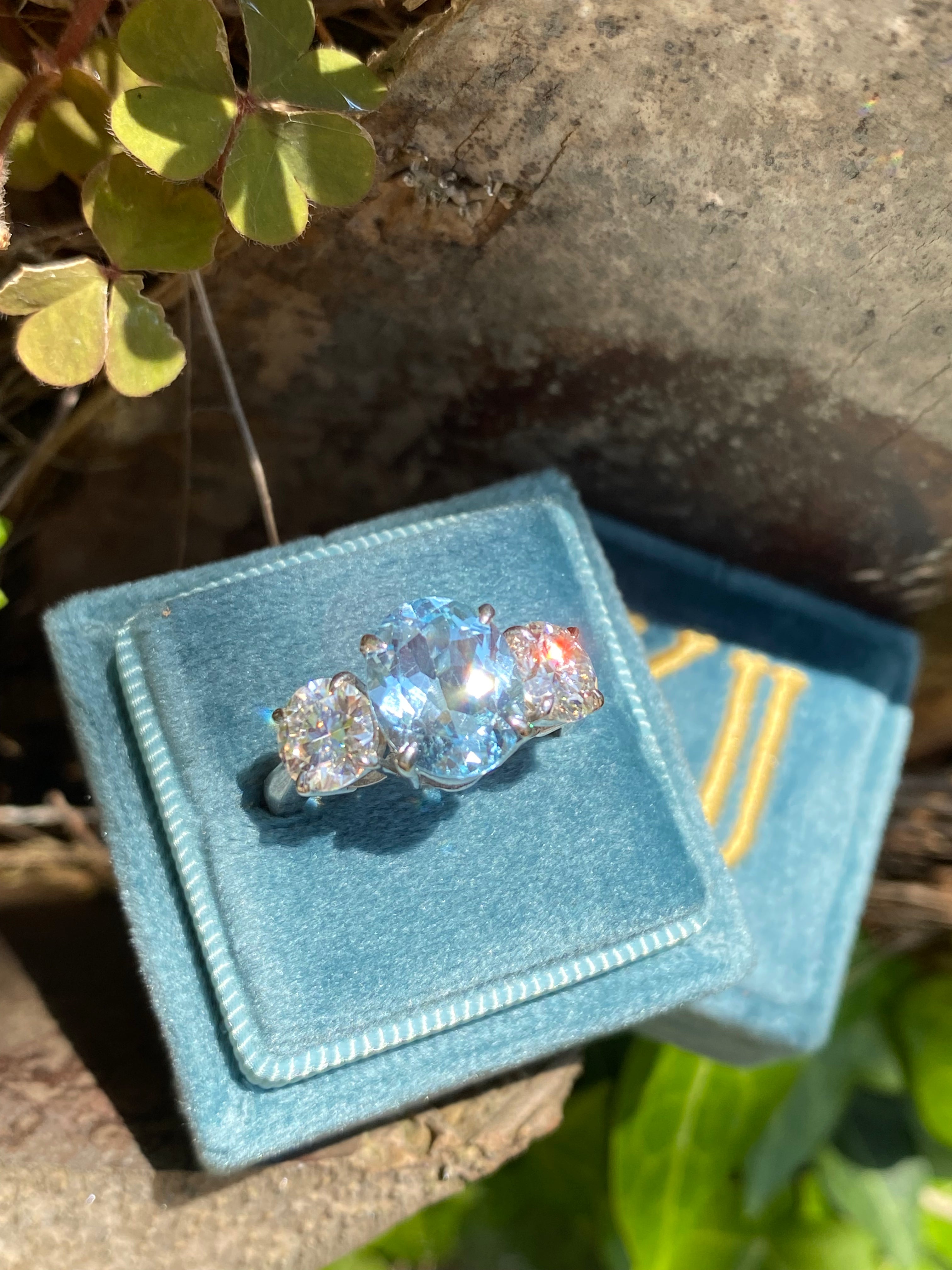 3.99 Carat Oval Cut Blue Topaz and 1.85 Carat Moissanite Three Stone Ring in Sterling Silver