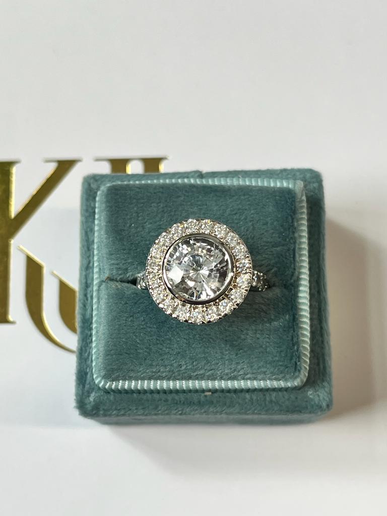 Round Cut Colourless White Sapphire and Diamond Halo Engagement Ring in White Gold 
